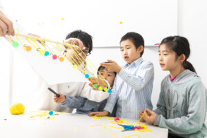 子どもたちがみらいミッテの習い事でペンデュラムウェーブの実験をしている様子