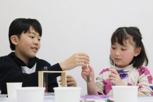 ２人の子どもがみらいミッテの習い事で実験をしている様子